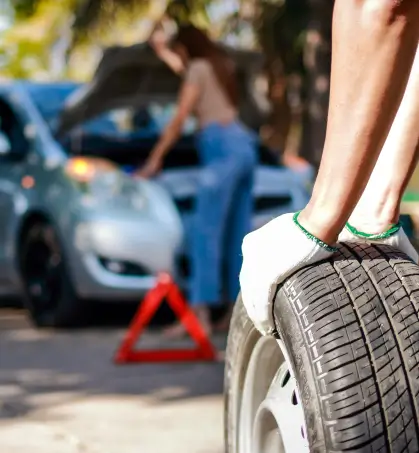 Mec&aacute;nico reparando las llantas de un veh&iacute;culo particular en referencia a la cobertura del seguro de responsabilidad civil vehicular de Seguros Caracas