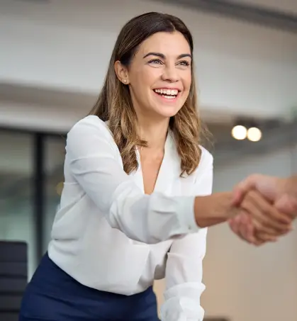 Ejecutiva estrechando la mano en referencia a la asistencia a la empresa en referencia los seguros de empresa de Seguros Caracas