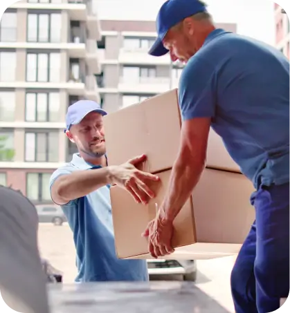 Dos personas de servicio de mudanza est&aacute;n descargando una caja en referencia a coberturas complementarias de seguros hogar de Seguros Caracas