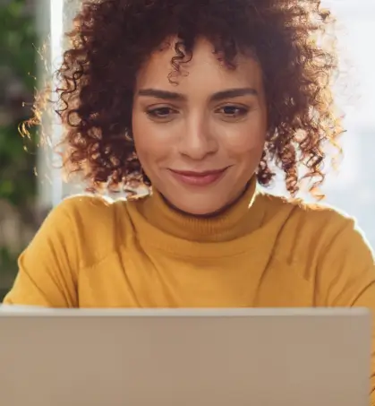 Mujer leyendo informaci&oacute;n en laptop en referencia a la p&oacute;liza de seguro de equipos electr&oacute;nicos de Seguros Caracas