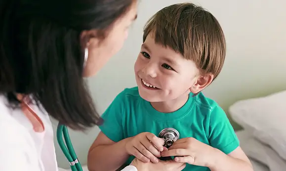 Doctora atendiendo un paciente ni&ntilde;o en la Cobertura para menores de edad en referencia a las p&oacute;lizas de salud de Seguros Caracas y sus beneficios