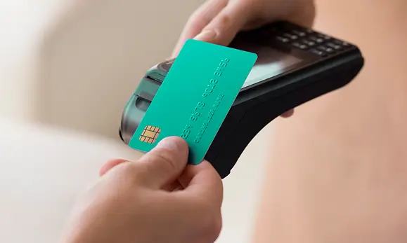 Paciente haciendo un pago con su tarjeta de cr&eacute;dito en referencia a los M&eacute;todos de pago de Seguros Caracas